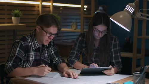 Young Adults Collaborating on Project at a Desk