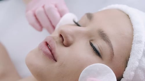Cropped View of Cosmetologist Cleansing Woman's Skin with Pads