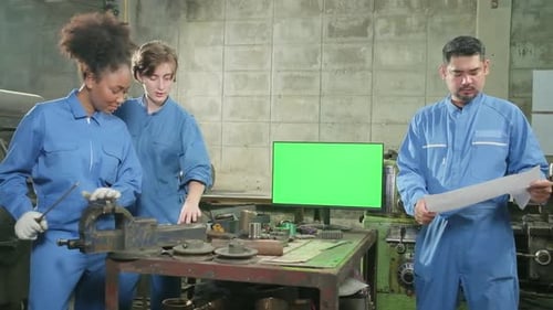 Multiracial professional workers teams in factory and green screen monitor.