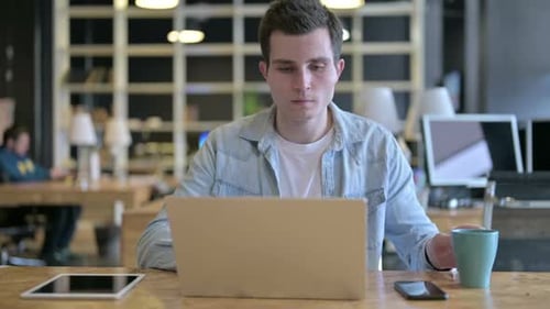 Hardworking Young Designer Drinking Coffee in Modern Office