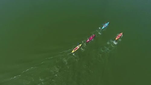 Aerial Top Down of Kayakers Competing on Dark Green River Surface