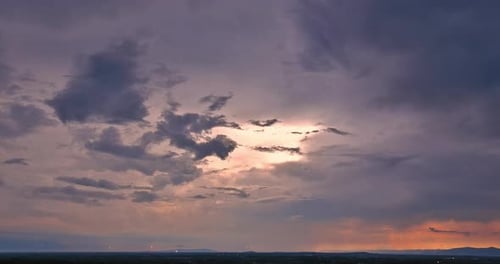 Ein brillanter orangefarbener Sonnenuntergang wird durch einen Dramatisch Blitzschlag ergänzt