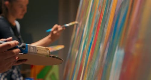 Painting Together Creating a Picture on a Canvas Located on an Easel Women Take Red