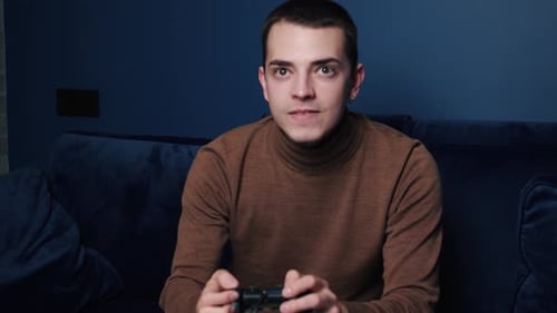 Young Adult Playing Video Game on Couch