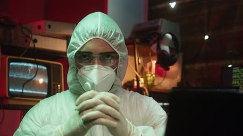 Man in Full Protective Suit in Dark Room