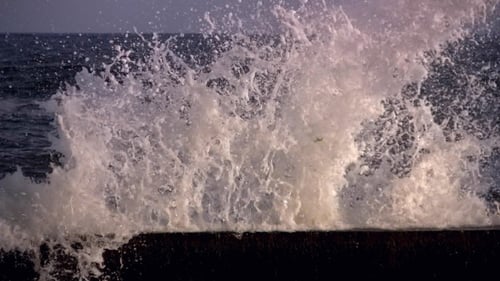Powerful Waves Crashing Against Concrete Sea Wall