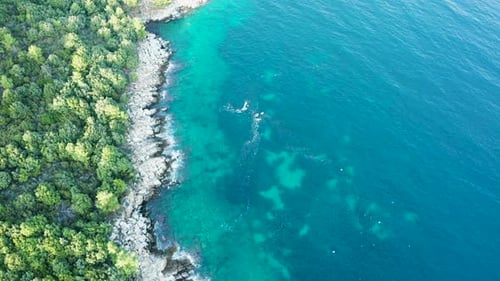 Drone Flying Along Rocky Coast Line with Waves Crushing Into the Coast Line