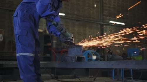 Man Grinding Metal with Sparks in Workshop