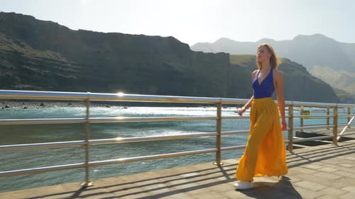 Woman Walking Along Ocean Coast in Yellow Skirt