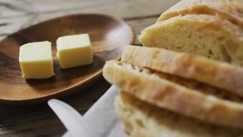 Video of bread on chopping wooden board on wooden worktop