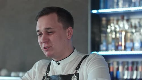 Friendly Bartender Talking Behind the Bar