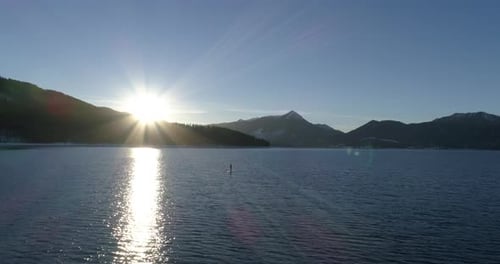 Aerial of man stand up paddle surfing on a lake in winter