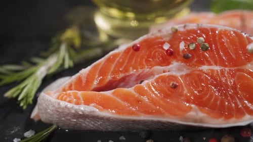 Salmon. Raw Trout Red Fish Steak with Herbs and Lemon and Olive Oil on Slate.