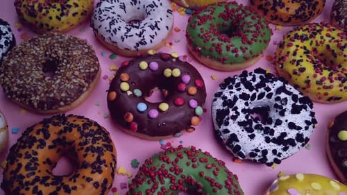 Assorted Colorful Donuts on a Pink Surface