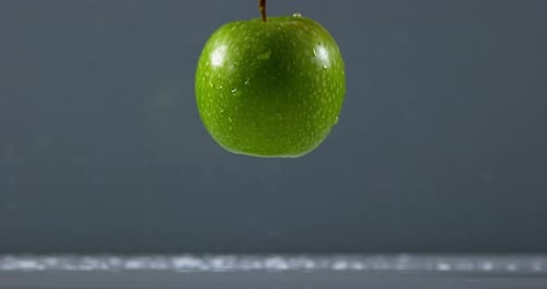 Granny Smith Apple, malus domestica, Fruit falling on Water against Black Background, Slow Motion 4K