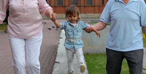 Grandparents and Child Walking in Urban Park