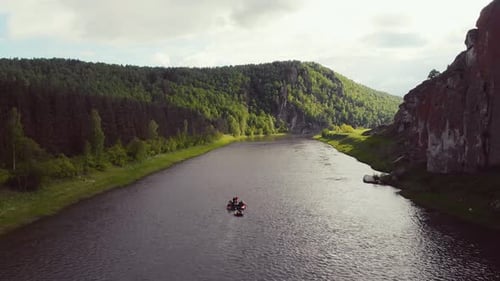 Luftaufnahme eines hellen Schlauchfloßes, das entlang der turbulenten Strömung des Dark River schwimmt