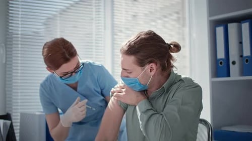 Female Doctor Injections of Vaccine with Syringe and Needle Against Covid in Medical Office