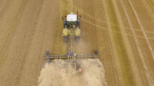 Tractor plows the field aerial.