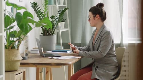 Woman Talking on Laptop in Home Office