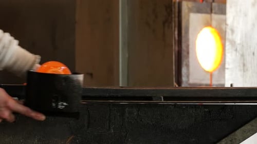 Glass Artist Shapes Hot Glass Bulb