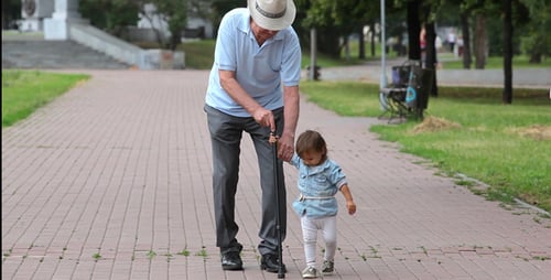 Senior Man Walking with Child in Park