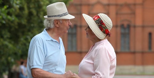 Loving Senior Couple Holds Hands and Converses