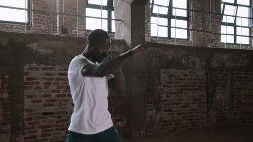 Man Shadow Boxing in an Industrial Gym
