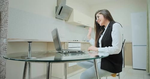 Woman Using Laptop for Video Call in Kitchen
