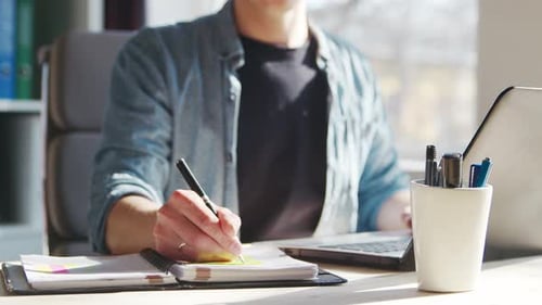 Young male entrepreneur works at home office at the computer.