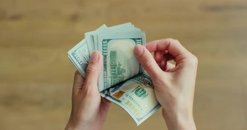 Frau zählt Hundert-Dollar-Scheine