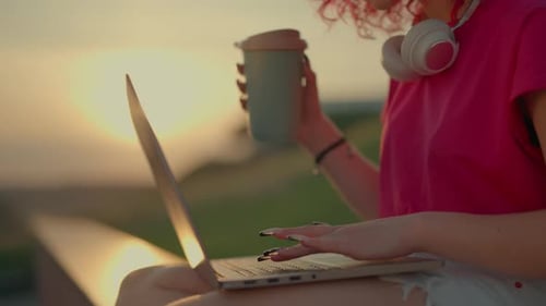 Young Adult Working on Laptop at Sunset
