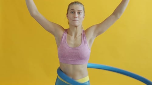 Woman Exercising with Hula Hoop in Studio