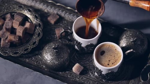 Cezve Pouring Black Coffee Out Oriental Cups in Istanbul