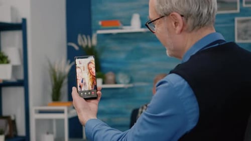 Senior Man Video Calling Family on Smartphone