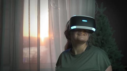 Das
Porträt einer aufgeregten jungen Frau verwendet ein Virtual-Reality-Headset und gestikuliert in Augmented Reality.