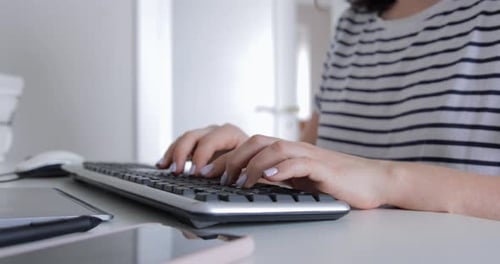 Nahaufnahme weiblicher Freelancer-Hände, während sie auf die Tastatur klickt und durch ein Computerprogramm navigiert
