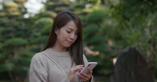 Woman use of mobile phone at park