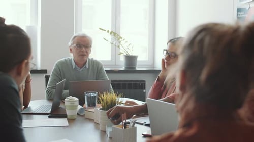 Senior CEO Talking to Multiethnic Young Team at Office Meeting