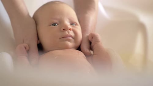 Adorable Infant Enjoying Bath Time with Wooden Bowl
