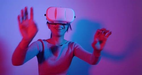 Woman Plays VR Game in Colorful Studio Lighting