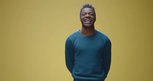 Young Adult Smiles and Holds a Mask