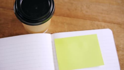 Coffee, notebook and sticky note on desktop