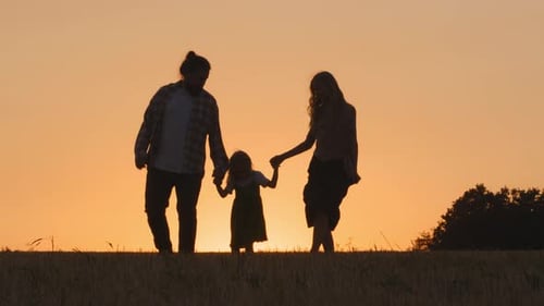 Family Silhouette Walking at Sunset in Rural Setting