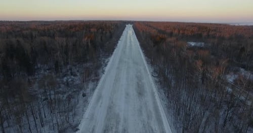 Aerial View of Empty Road in Winter Woods