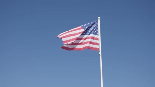 American Flag Waving Against Blue Sky