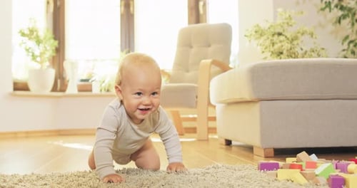 Happy Baby Crawls Towards Colorful Wooden Blocks