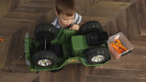 Boy Repairing Toy Car at Home