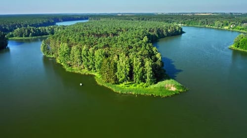 Small fishing boat near small forest island on lake