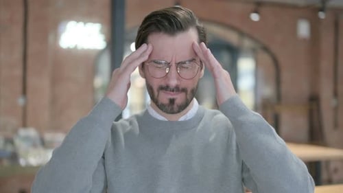 Man With Headache Massaging Temples